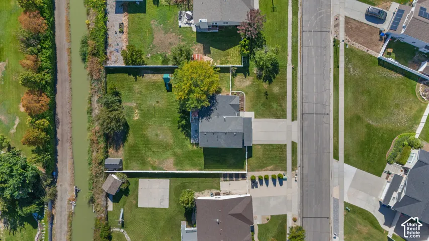Expansive residential lot with a paved driveway and mature trees
