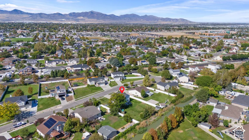 Expansive suburban landscape with distant mountains and a prominent water feature