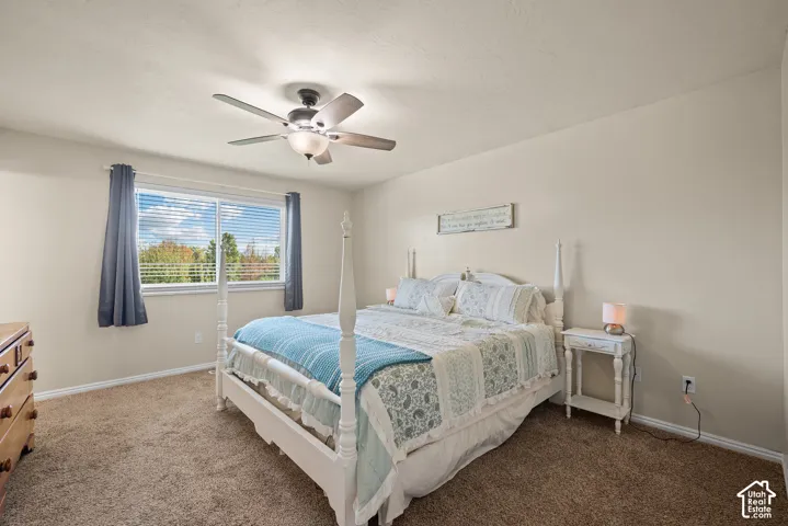 Neutral wall paint, ceiling fan with integrated lighting, wood-finish flooring, and a window with horizontal blinds