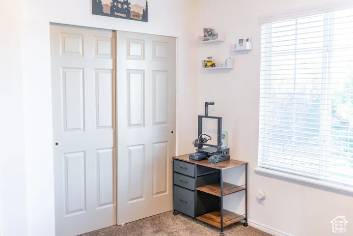 Built-in closet with panel doors, wall-mounted shelving, and a large window with blinds