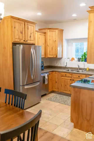 Kitchen featuring wood cabinetry, stainless steel appliances, recessed lighting, and tile flooring