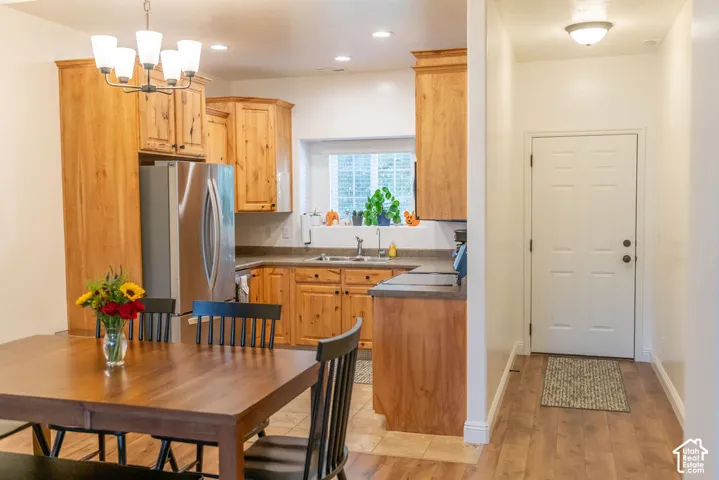 Kitchen featuring wood-finish cabinetry, stainless steel refrigerator, and a built-in sink