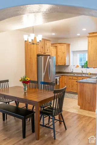 Kitchen with wood-finish cabinetry, stainless steel refrigerator, and recessed lighting