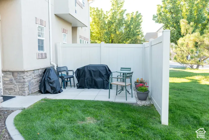 Private patio space featuring a solid privacy fence