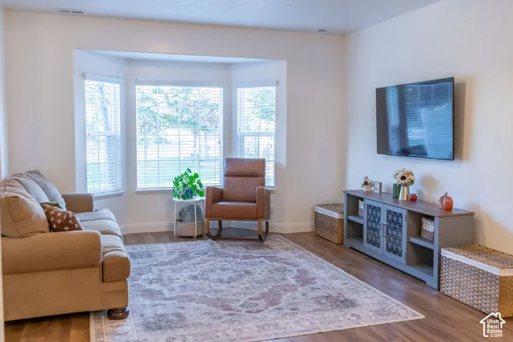 Bay window with multiple panels, wood-finish flooring, and light-toned walls