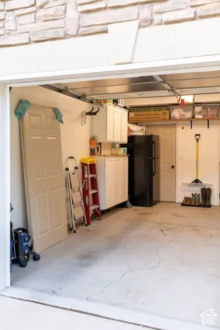 Garage interior featuring built-in cabinetry, overhead shelving, and a concrete floor