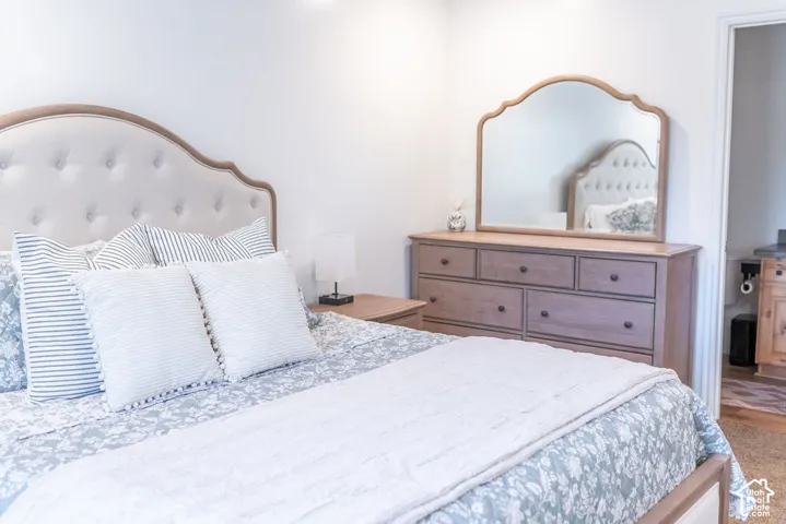 Tufted upholstered headboard with a wood-finish frame, multi-drawer dresser, and a decorative wall mirror