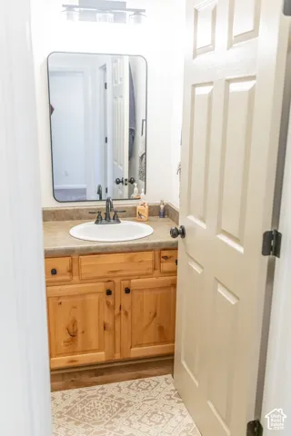 Vanity with a round basin, a dark finish faucet, and a light-toned countertop
