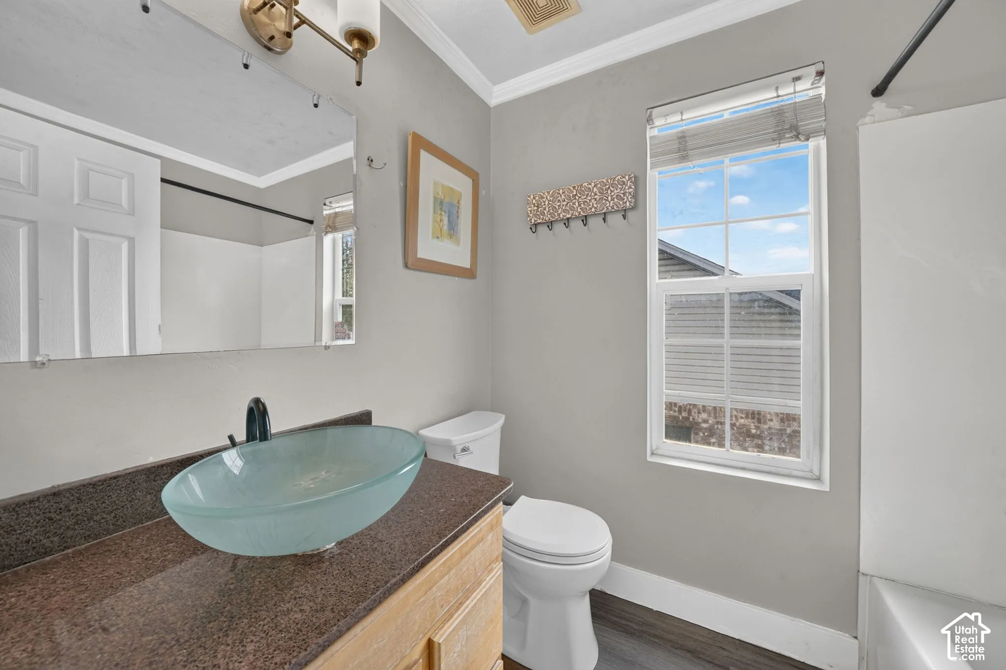 Vanity with a glass vessel sink, dark countertop, and matte black faucet
