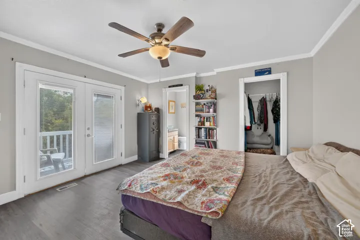 Wood-finish flooring, ceiling fan with integrated lighting, double French doors, white crown molding, and recessed closet