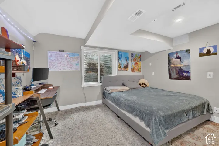 Recessed ceiling lighting, window with white trim, light gray walls, gray carpet, and a built-in ceiling soffit