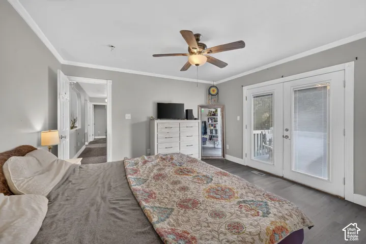 Dark wood-finish flooring, ceiling fan with integrated lighting, and white trim work
