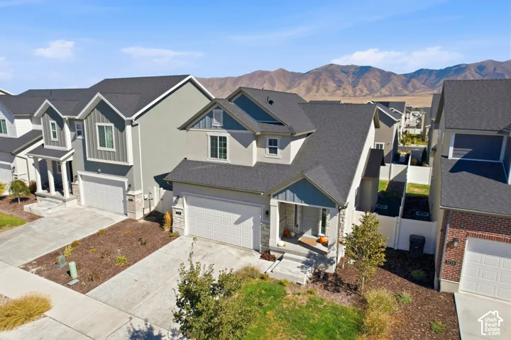 Modern traditional exterior with varied siding, an attached garage, and a covered front porch