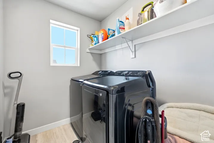 Laundry area featuring light gray walls, a built-in white shelf, and wood-finish flooring