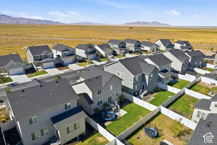 Residential community with a uniform architectural style, paved streets, and expansive undeveloped land in the background