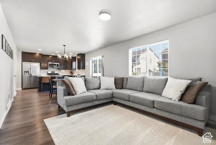 Open-concept living space with wood-finish flooring, recessed lighting, and a large window