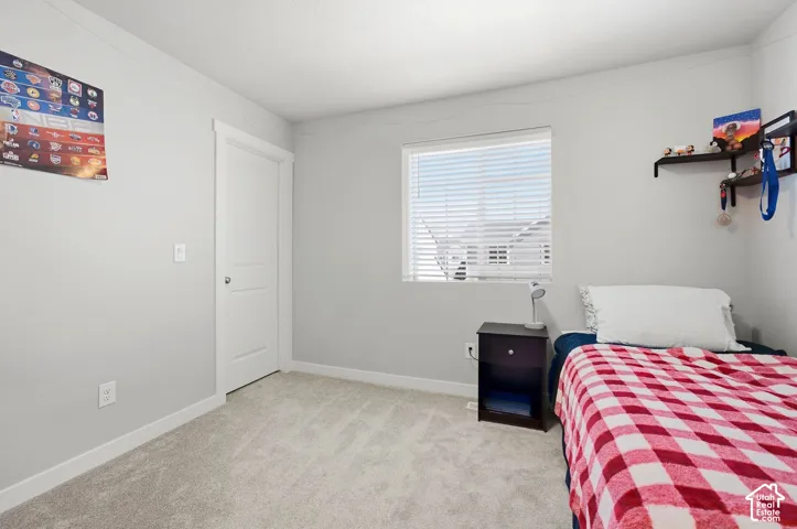 Light gray wall paint, white trim, carpet flooring, single window with blinds, and a white interior door