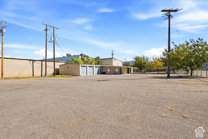 Asphalt paving, multiple utility poles, and mature trees