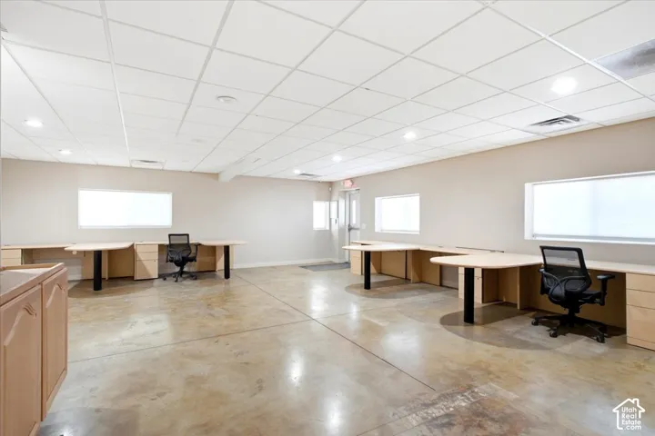 Open-concept workspace featuring concrete flooring and a drop ceiling with recessed lighting
