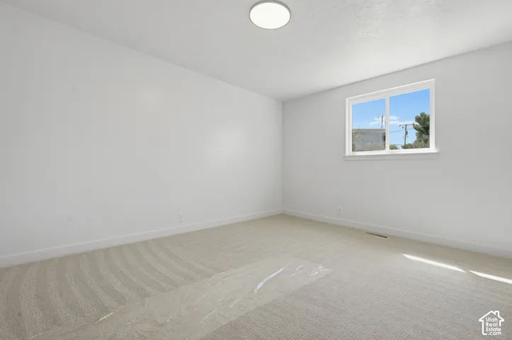 Recessed window with white trim, light-colored carpeting, white wall finishes, and a flush-mount ceiling light fixture