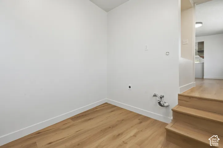 Wood-finish flooring with white baseboards and light-colored walls