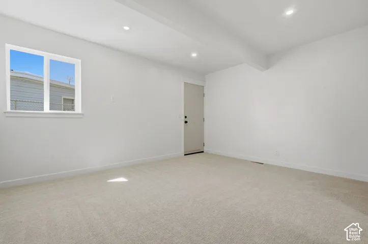 Recessed lighting, light-colored carpeting, white walls, white trim, and a white window frame