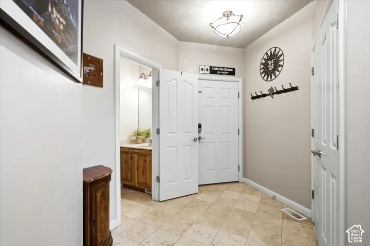 Tiled flooring, white paneled doors, recessed lighting, and a vanity with a base cabinet