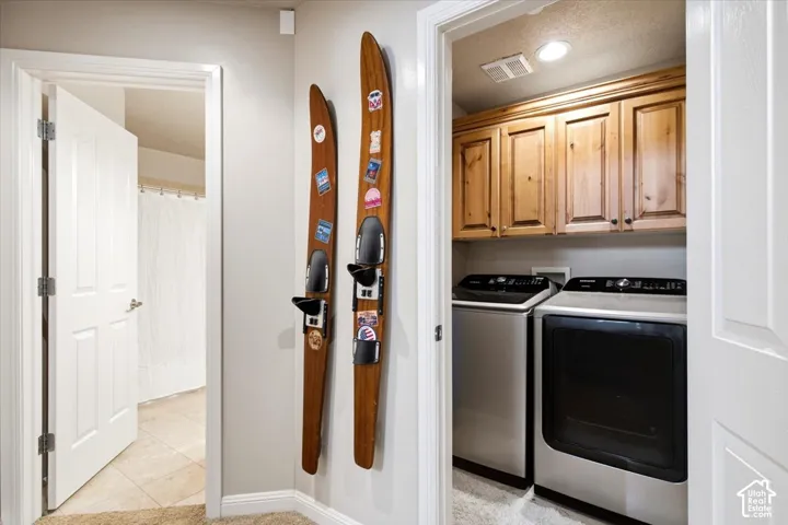 Dedicated laundry area with upper wood-finish cabinetry