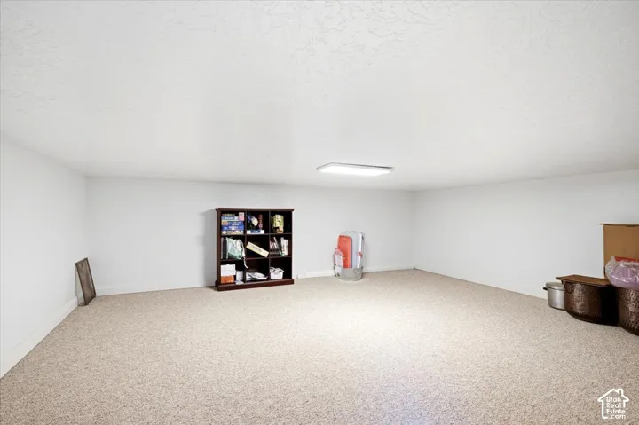 Recessed ceiling lighting, light neutral-toned carpet, and painted white walls