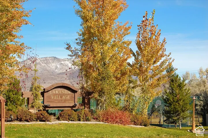 Lakeside Village entry sign with mature trees, established landscaping, and mountain backdrop