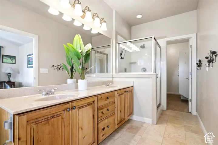 Dual vanity with light-toned countertop, wood-finish cabinetry, and chrome fixtures