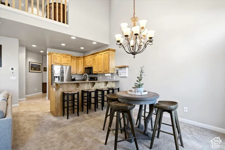 Kitchen with wood cabinetry, stainless steel refrigerator, and recessed lighting