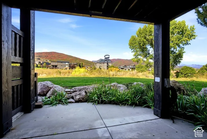Covered patio with concrete flooring, framed by dark wood pillars