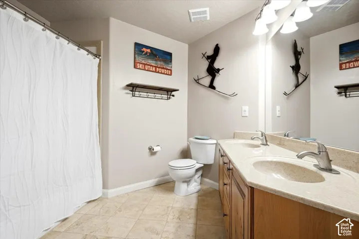 Double vanity with integrated sinks, light-toned countertop, and wood-finish cabinetry