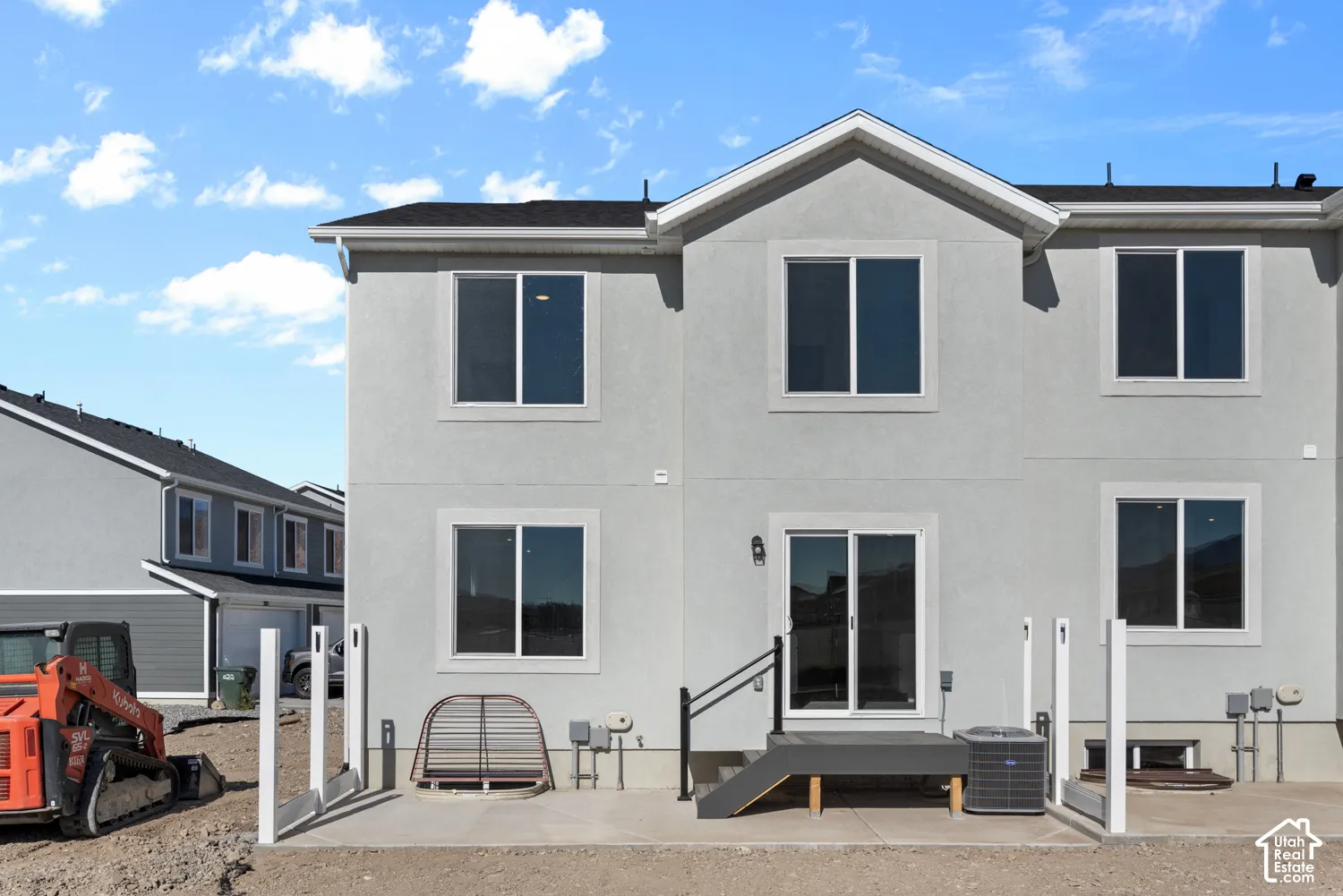 Stucco exterior with multiple windows and a sliding glass door