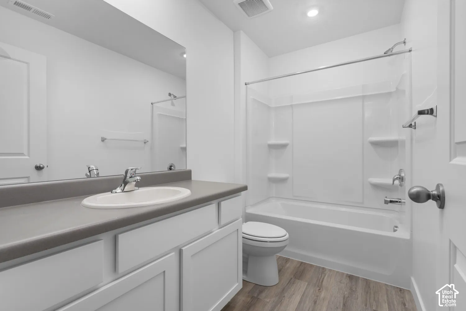 White vanity with shaker-style cabinetry and a gray countertop