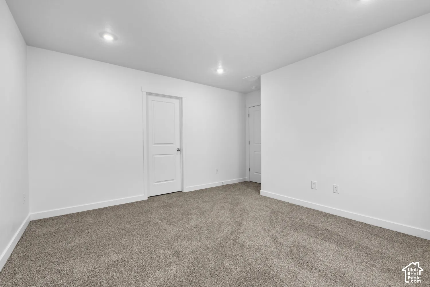 Recessed ceiling lighting, white interior doors, and neutral carpeting