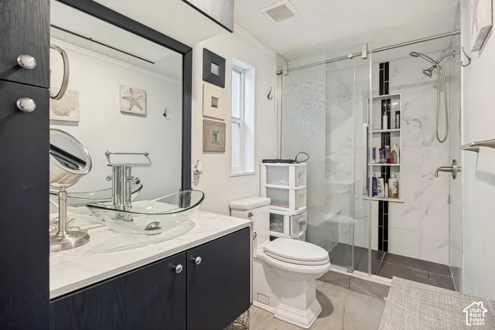 Vessel sink with a sleek vanity, a large framed mirror, and a glass-enclosed shower with tiled walls and a built-in niche