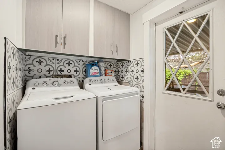 Built-in upper cabinetry, patterned wall tile, and a white paneled door with a decorative window