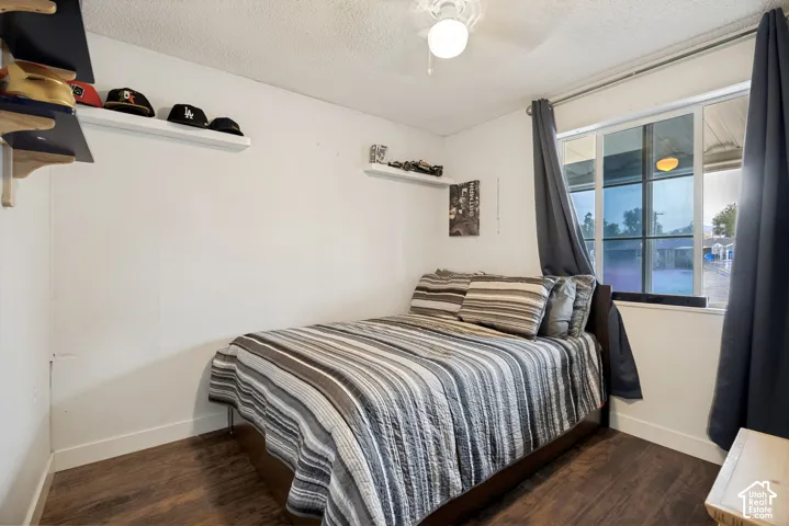 White walls with wood-finish flooring, featuring a window and a ceiling fan with an integrated light fixture