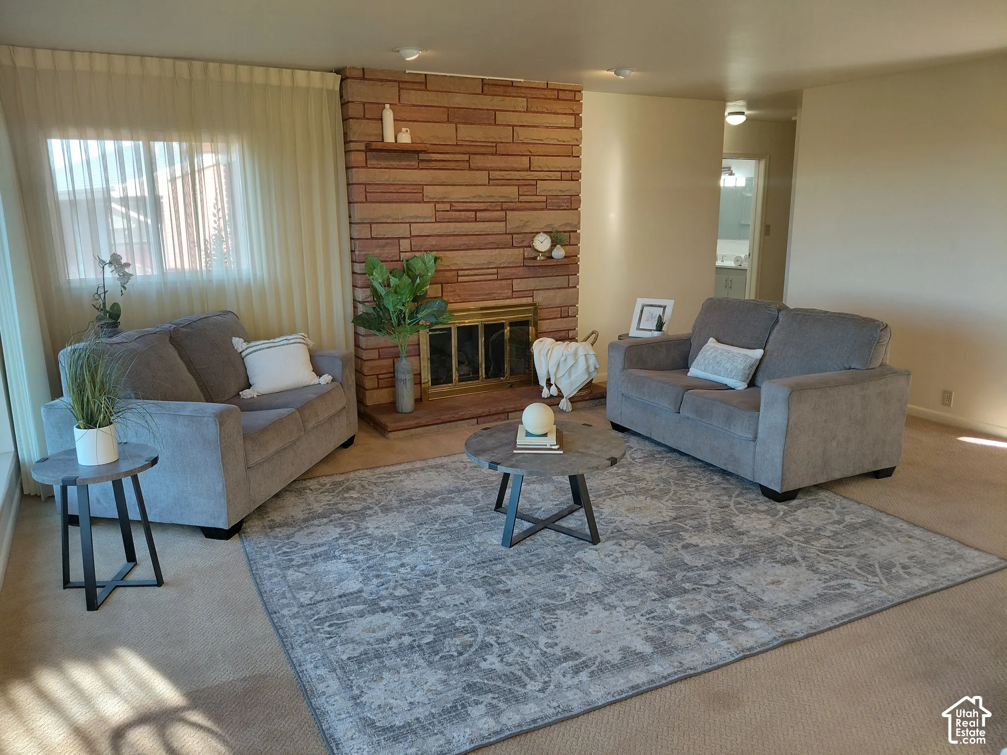 Stone-clad fireplace with mantel, built-in shelving, and metal firebox