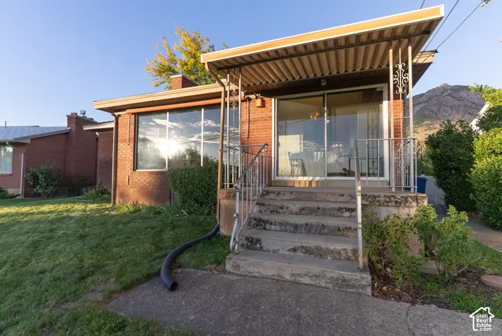 Brick exterior with a covered porch, sliding glass door, and large picture window