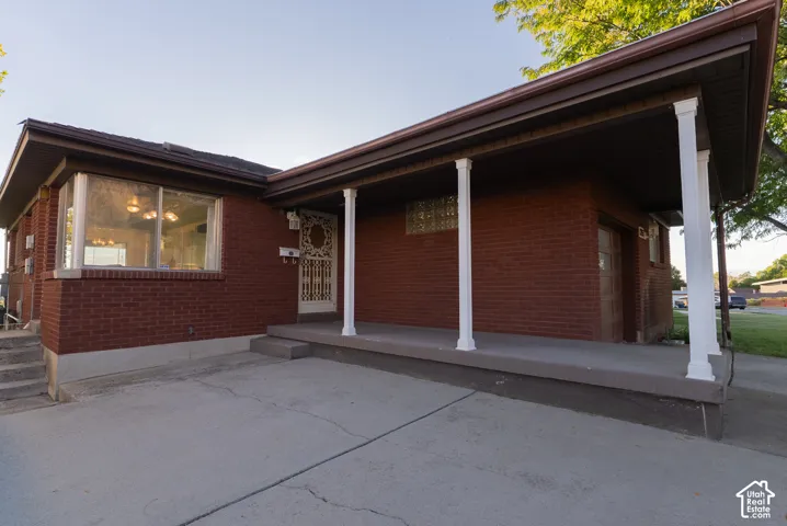 Brick exterior with a covered porch featuring white columns