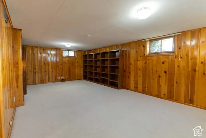 Wood-paneled walls with built-in shelving, windows, and overhead lighting