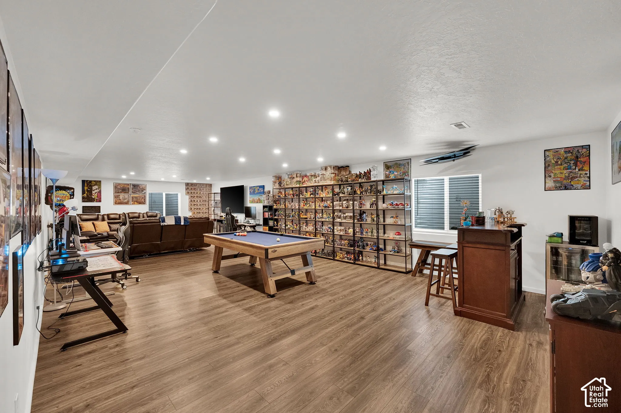 Spacious room featuring wood-finish flooring & recessed lighting.