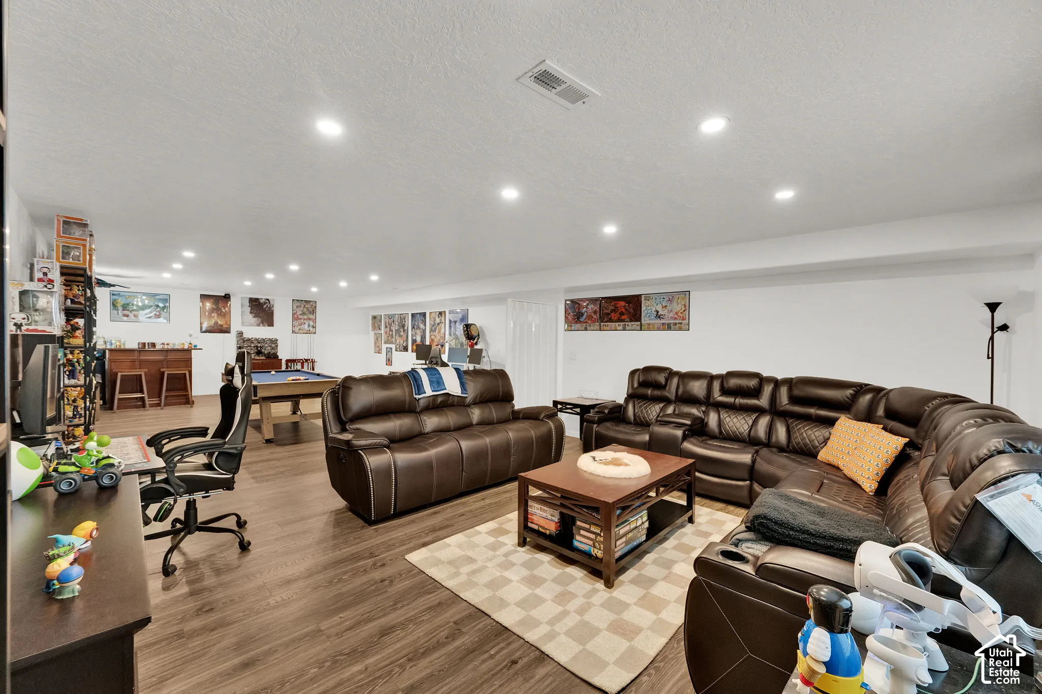 Spacious entertainment room featuring wood-finish flooring & recessed lighting.