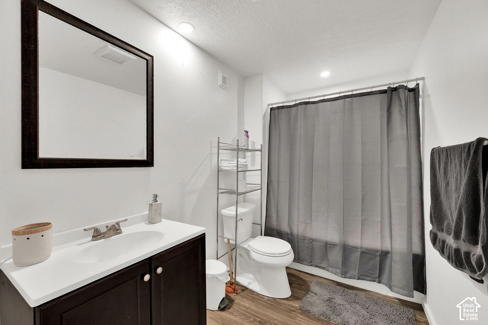 Full bathroom down. Vanity with integrated sink & framed wall mirror.