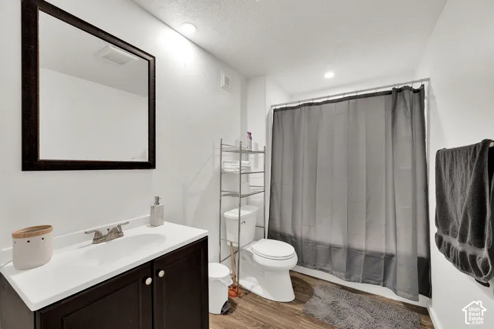 Full bathroom down. Vanity with integrated sink & framed wall mirror.