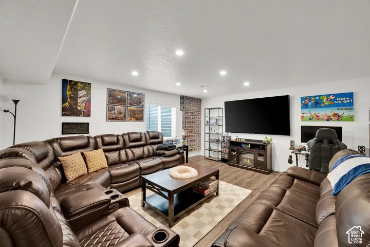 Recessed ceiling lighting, wood-finish flooring, and a window with horizontal blinds