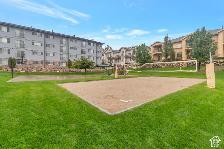 Expansive green space featuring a sand volleyball court and a basketball court